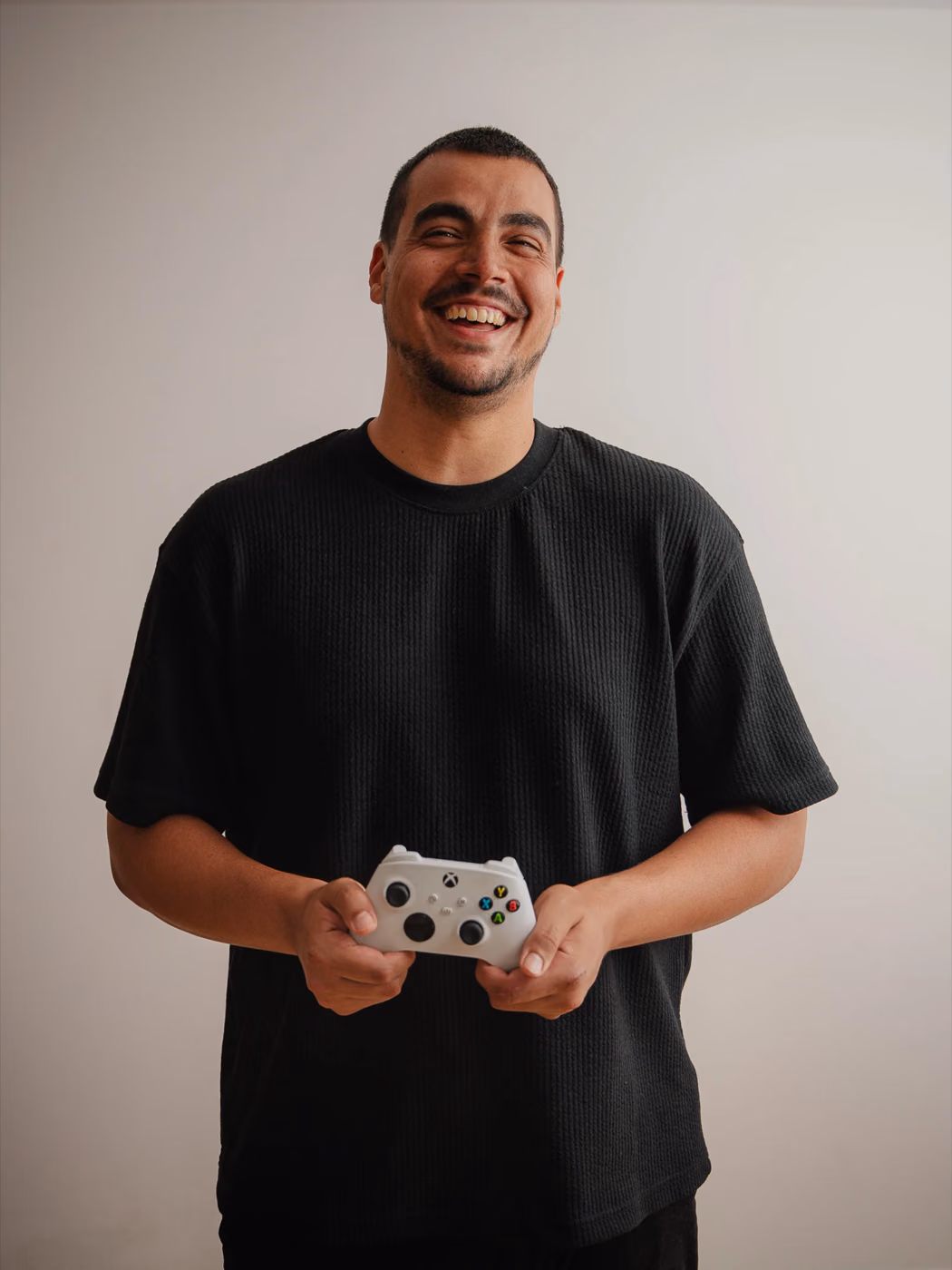 Joaquín González smiling with a white Xbox controller in his hands